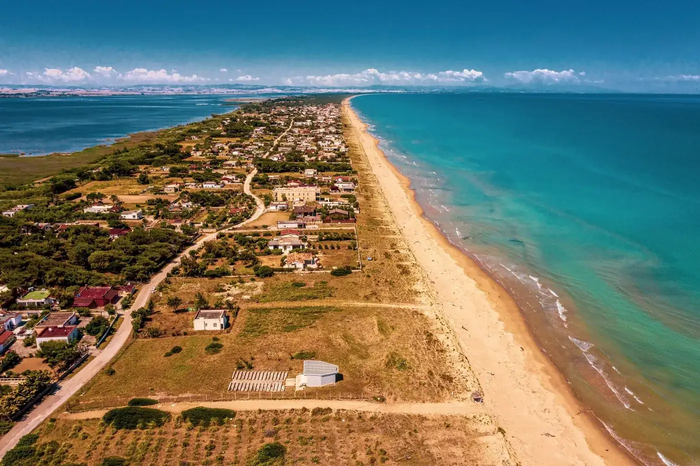 Stunning aerial view of Torre Mileto, Puglia with coastline and town under summer sky.