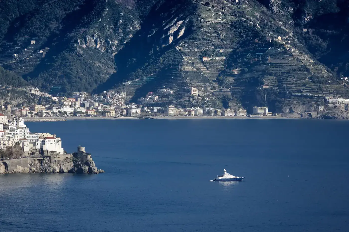 Yacht sailing near the picturesque Amalfi Coast, showcasing Mediterranean charm.