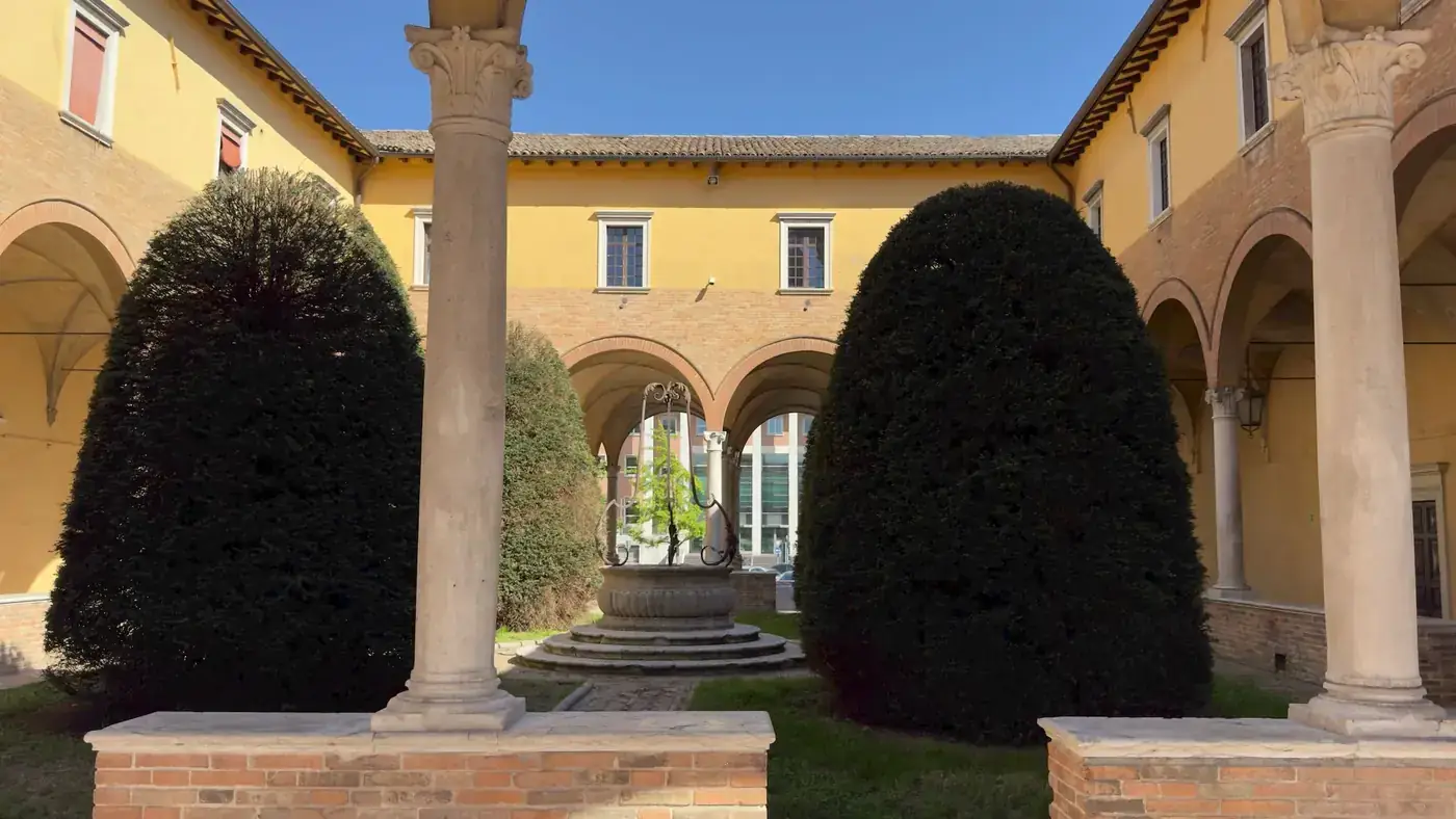 Captivating view of a historic Italian courtyard framed by arches and quaint topiary.