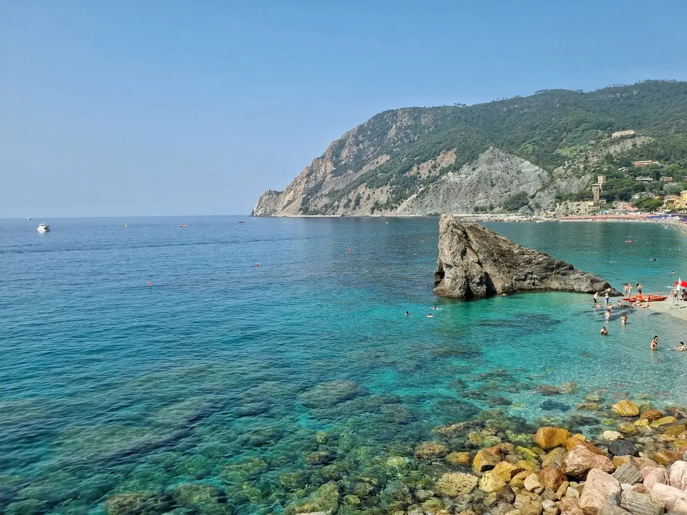 Clear turquoise waters and rocky coastline at Monterosso Beach, Liguria, Italy.