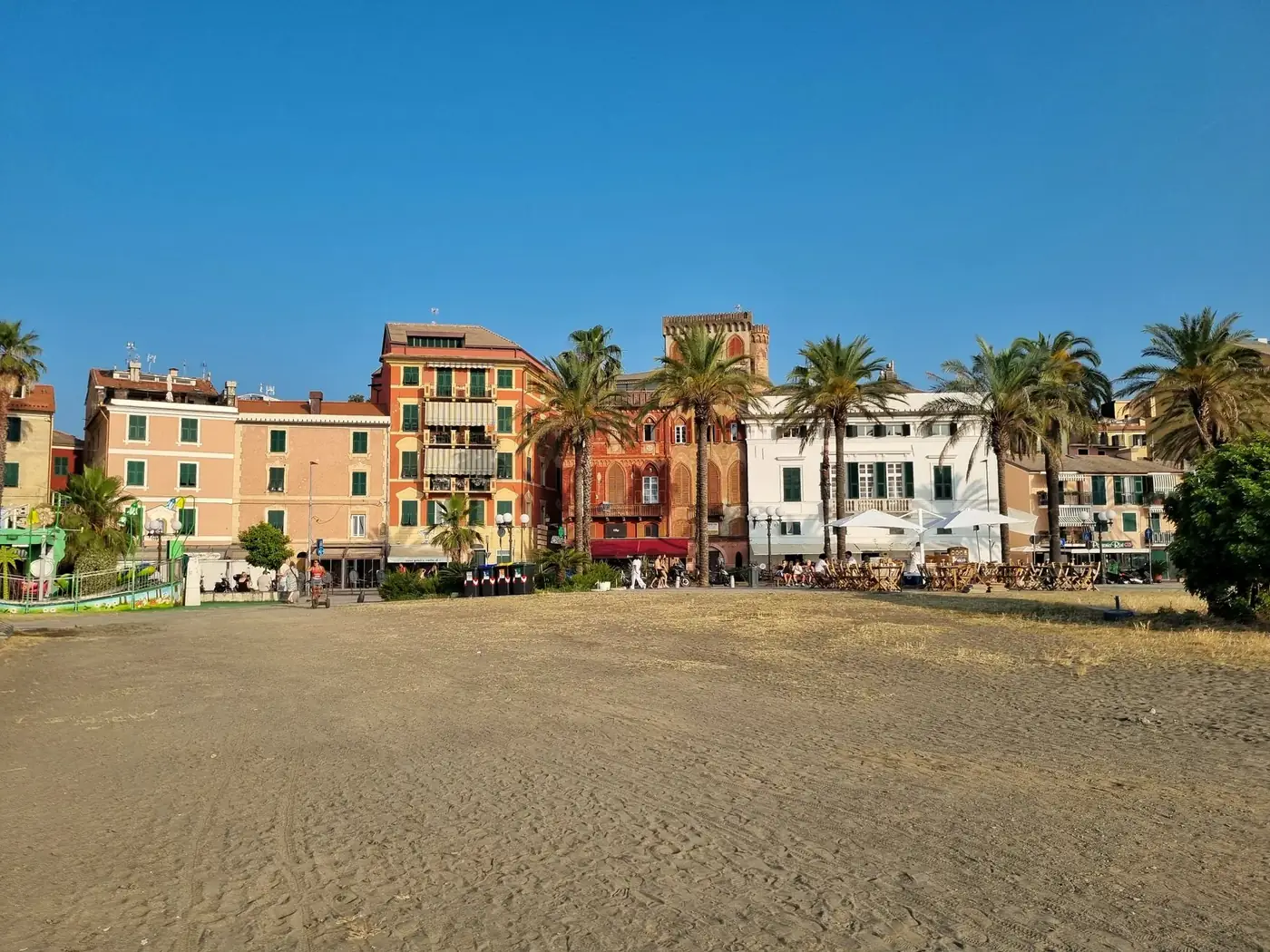 Vibrant buildings and palm trees along the beachfront in Sestri Levante, Liguria, Italy.