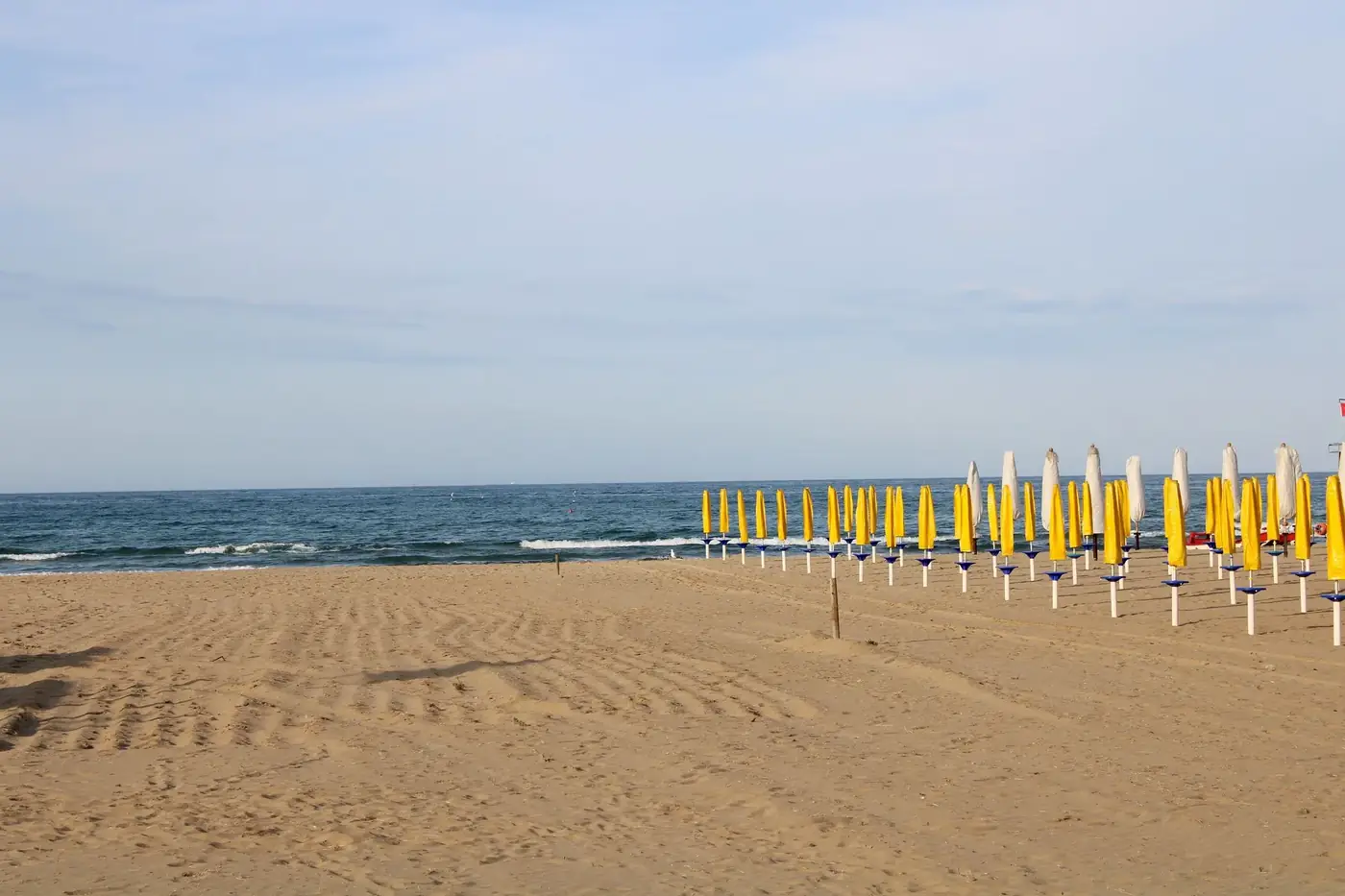 A serene summer beach scene with yellow umbrellas in Abruzzo, Italy.