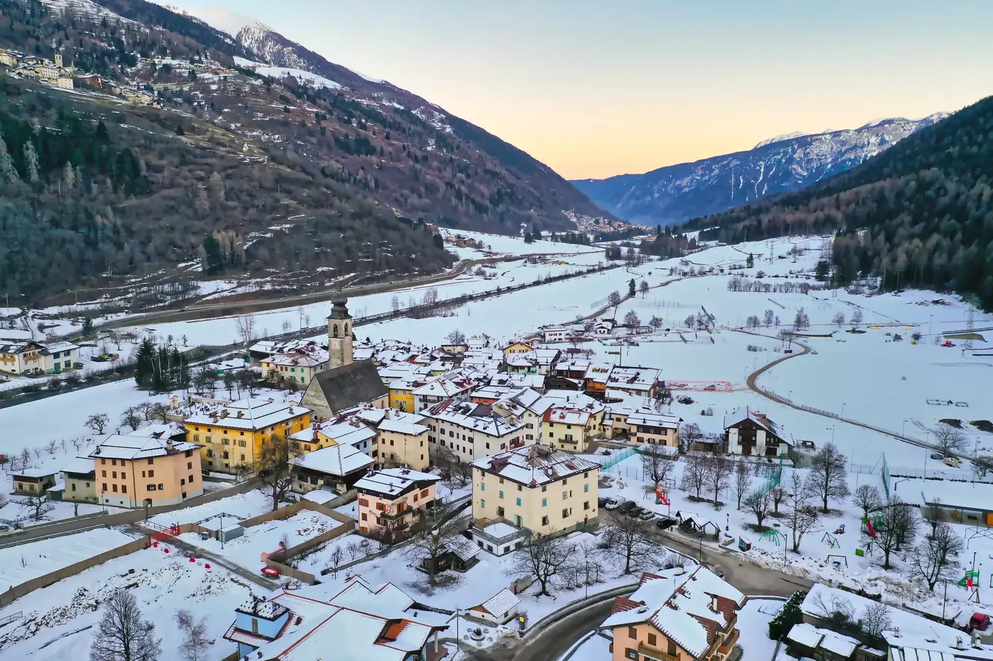 Aerial view of snow-covered Pellizzano in Trentino-Alto Adige, Italy, during winter twilight.