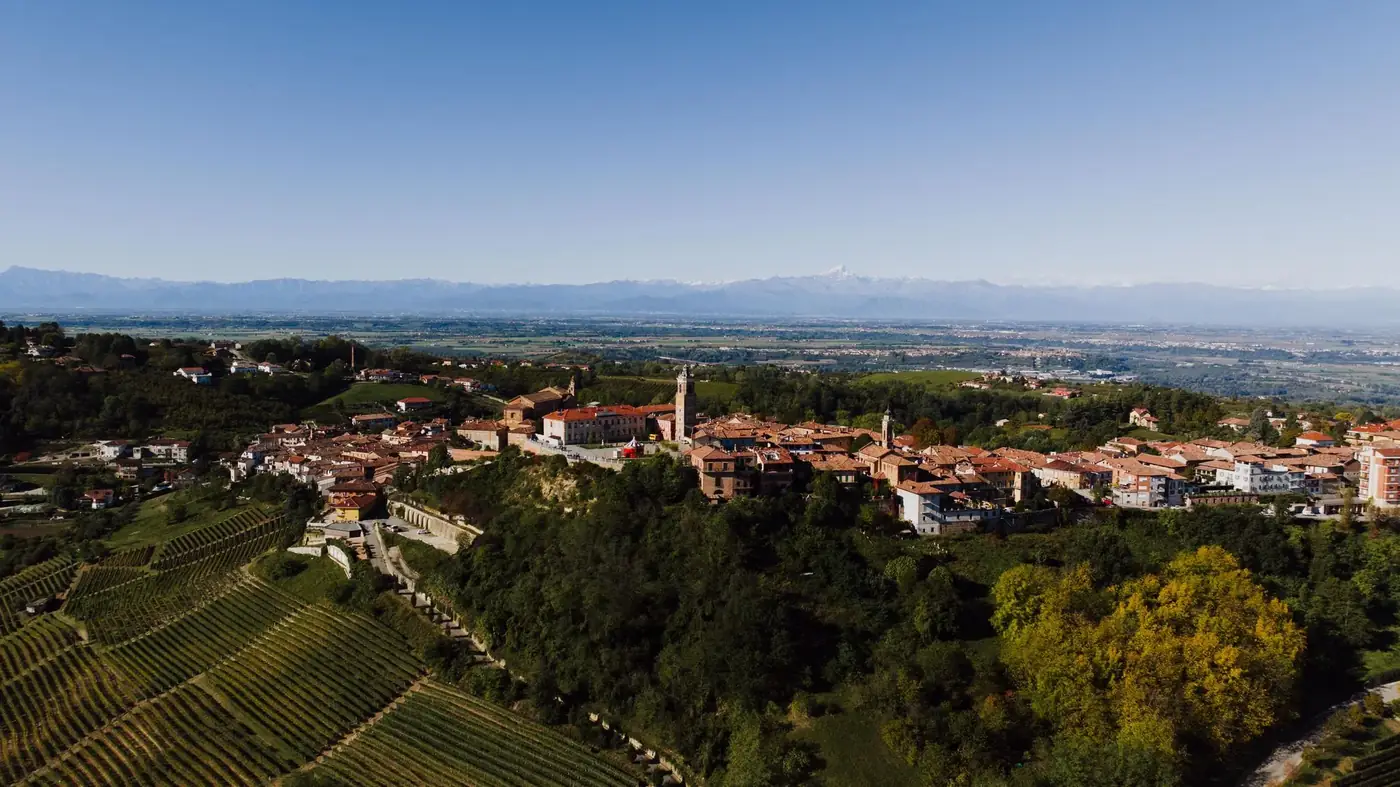 A stunning aerial view of La Morra, Piemonte, Italy, showcasing vineyards and historic architecture in summer.