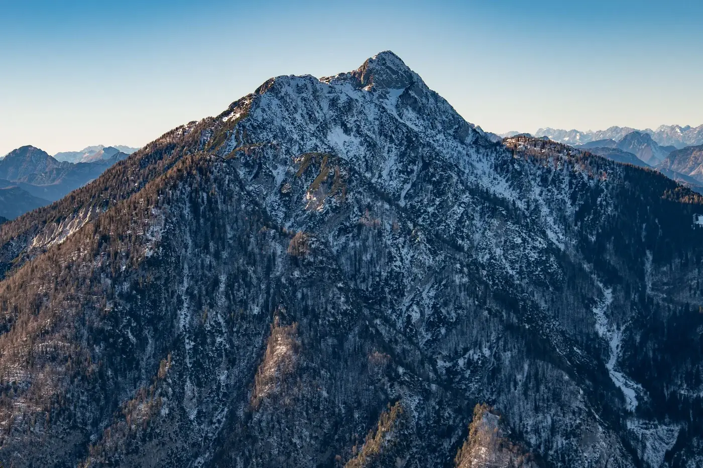 A breathtaking view of a snowy mountain peak in Furlanija-Julijska krajina, Italy, on a clear day.