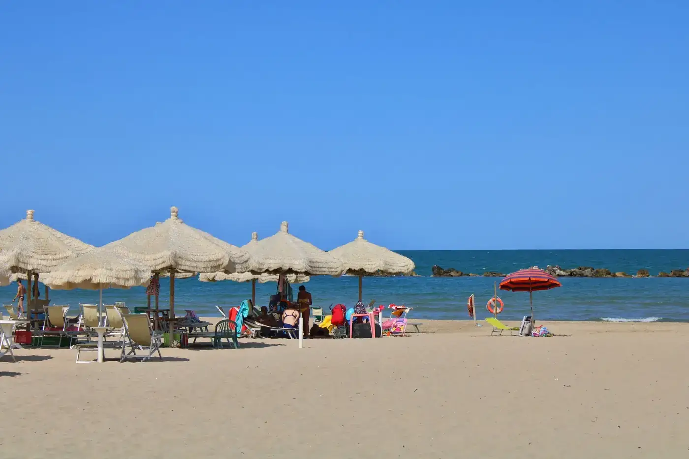 Relax by the sea under umbrellas on Fossacesia beach, Abruzzo, Italy.