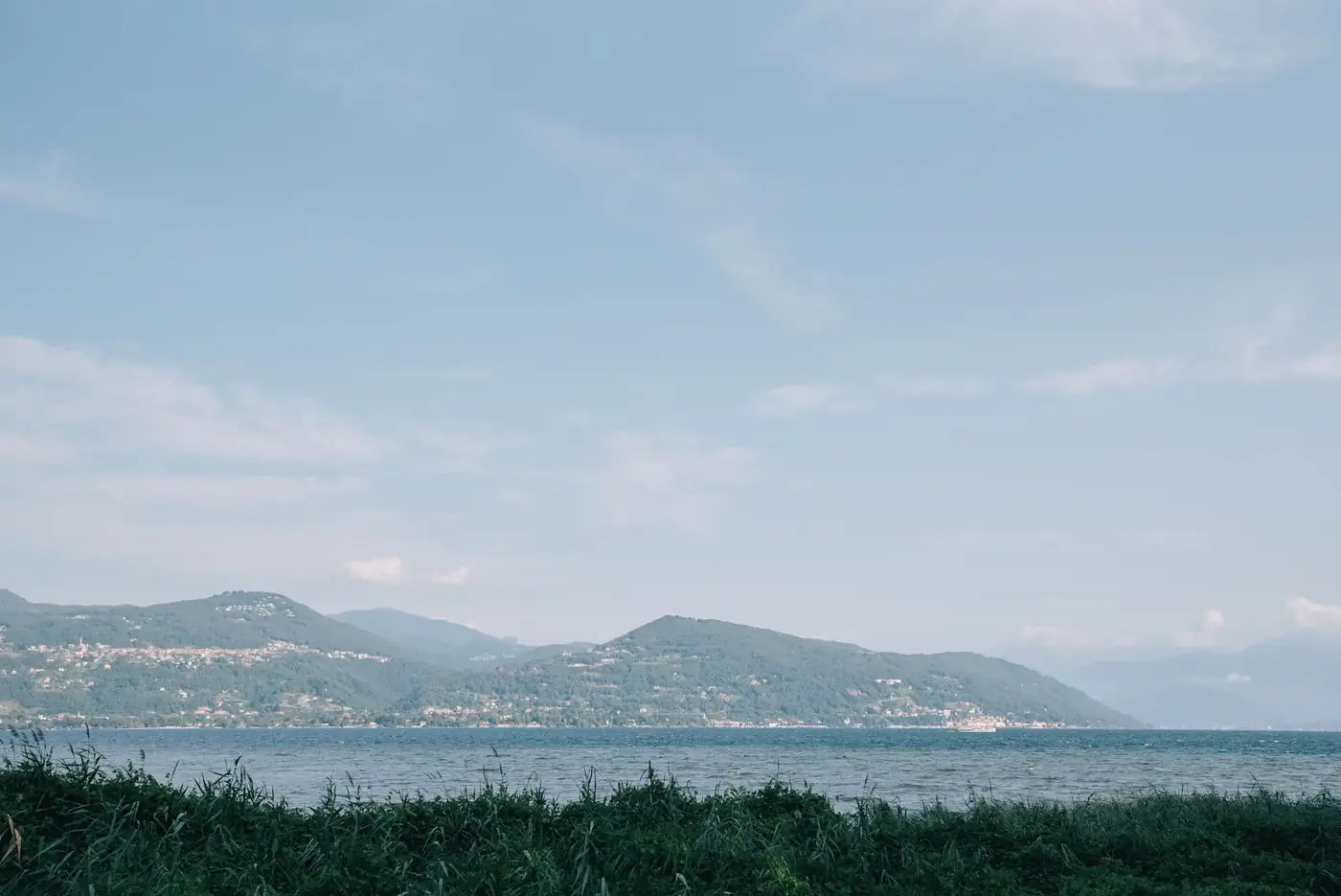 Breathtaking landscape of Lake Como with distant mountains under a blue sky.