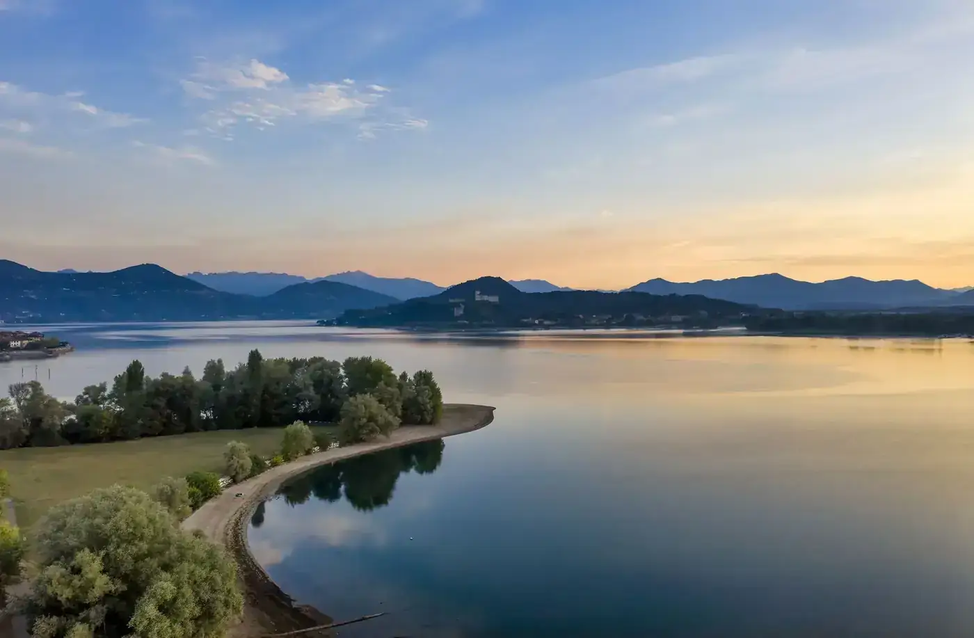 A breathtaking aerial view of Lake Varese during sunset, with serene waters and distant mountains.
