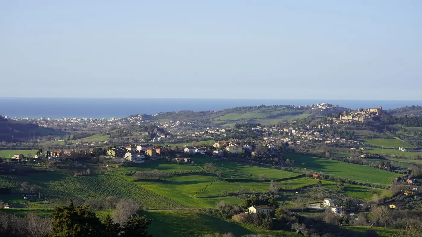 Scenic aerial view of a coastal town surrounded by lush green countryside and sea.