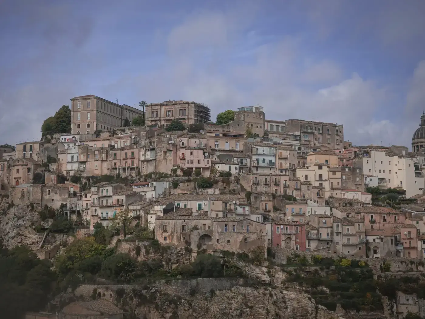 Charming view of a historic hilltop town in Italy, showcasing ancient stone buildings and scenic architecture.