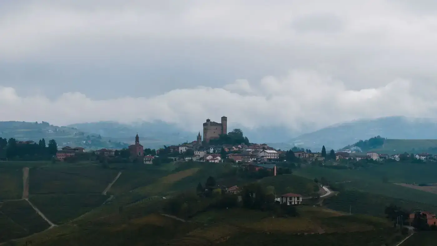 Scenic aerial view of Monforte d'Alba, Piedmont, Italy with historic architecture and lush vineyards.