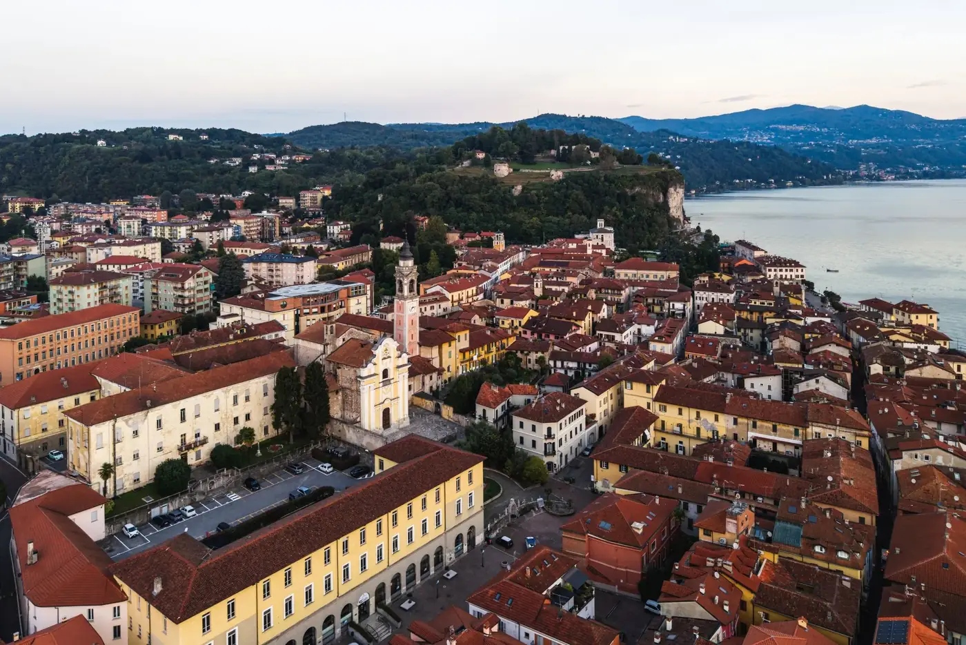 Stunning aerial view of a charming Italian town with red-roofed buildings by a serene lake.