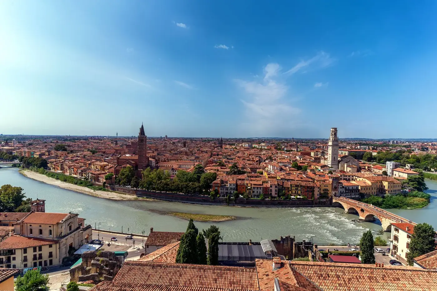 Stunning aerial view of Verona cityscape, featuring the Adige River winding through historic architecture under a clear 
