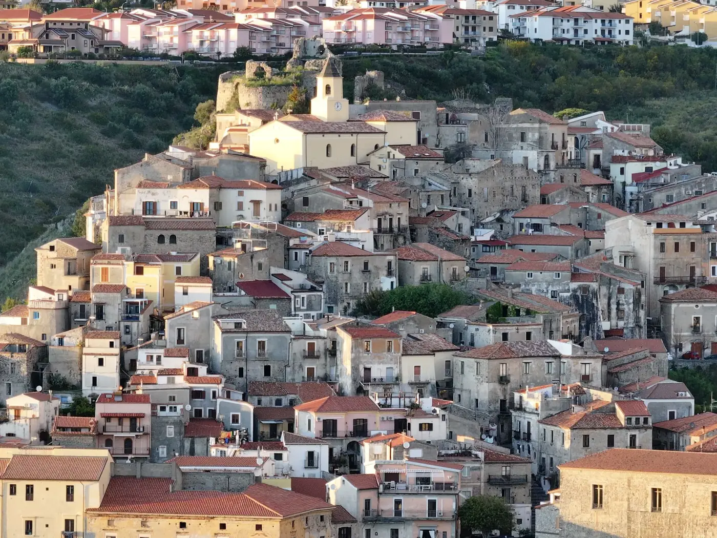 Aerial view of a historic Italian village with charming red tiled roofs and stone buildings.