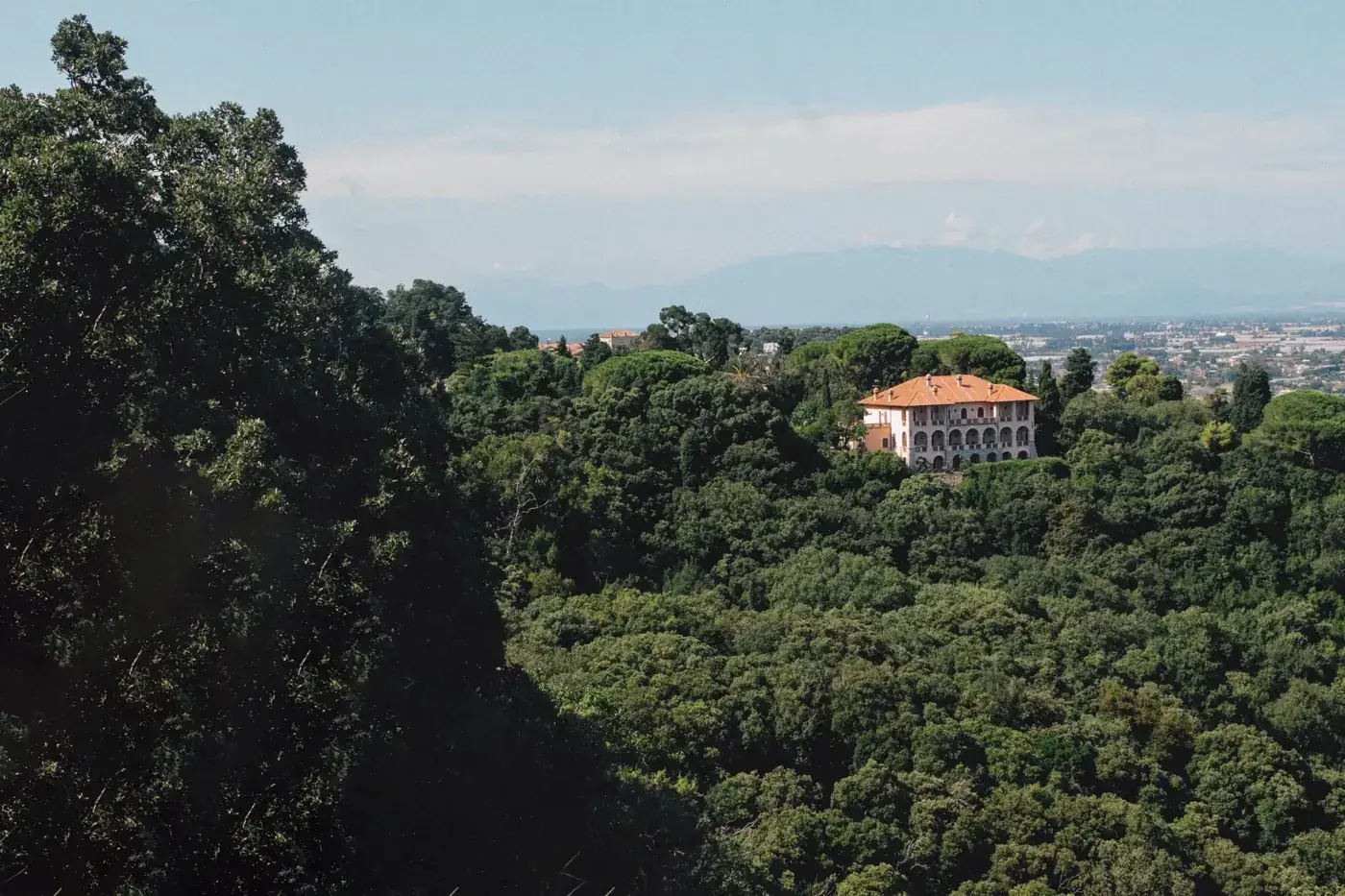 A scenic view of Villa Aguet nestled in the verdant hills of San Felice Circeo, Italy.