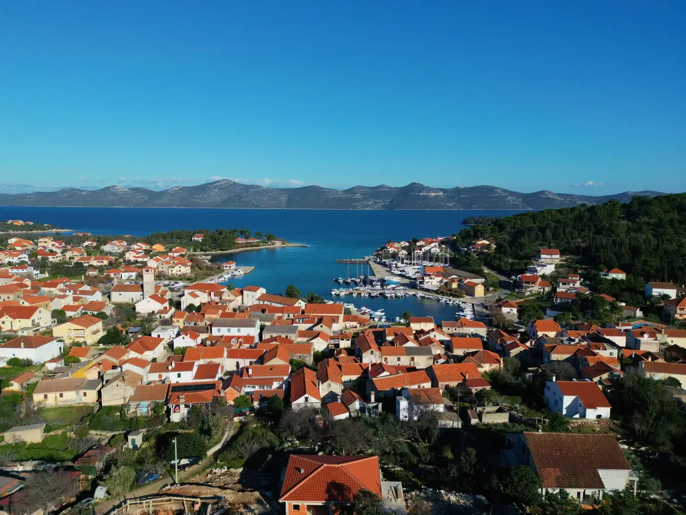 Aerial view of Veli Iž, Croatia showcasing the picturesque coastal town and marina.