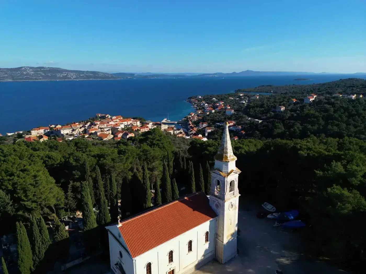 Aerial view of Veli Iž and its coastline in Croatia, showcasing a picturesque village and clear sea.
